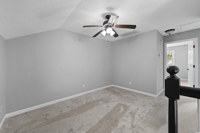 interior space featuring lofted ceiling, visible vents, attic access, a textured ceiling, and baseboards