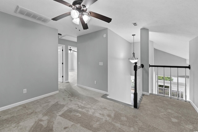 carpeted spare room featuring vaulted ceiling, a ceiling fan, visible vents, and baseboards