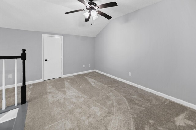 empty room featuring ceiling fan, lofted ceiling, and light carpet