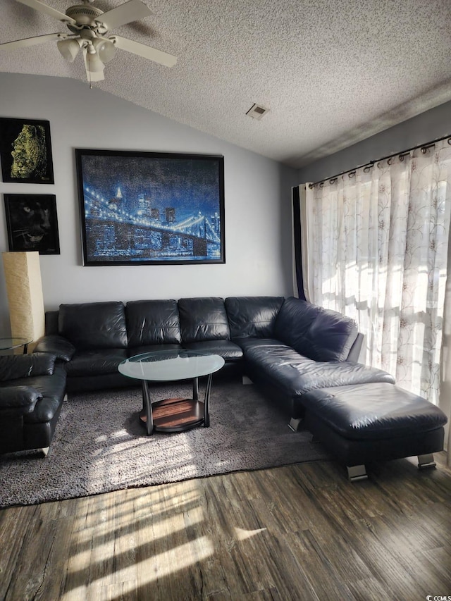 living room with ceiling fan, wood-type flooring, lofted ceiling, and a textured ceiling