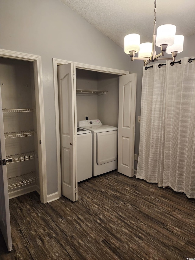 washroom with a textured ceiling, a notable chandelier, dark wood-type flooring, and washing machine and clothes dryer