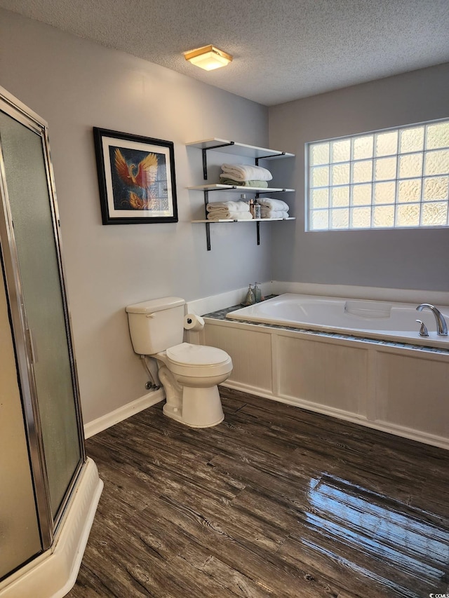 bathroom with toilet, wood-type flooring, a textured ceiling, and independent shower and bath