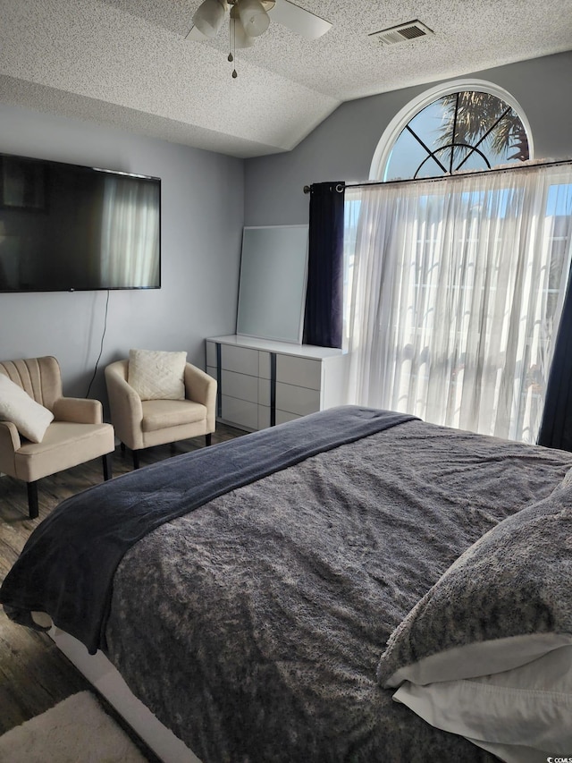 bedroom featuring a textured ceiling, vaulted ceiling, and ceiling fan