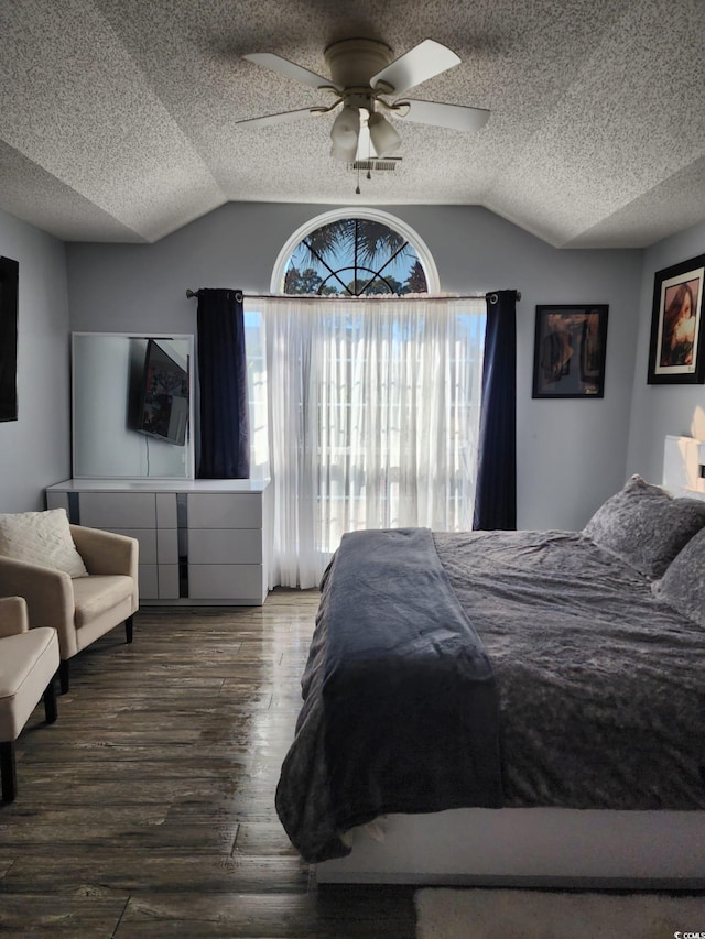 bedroom with a textured ceiling, ceiling fan, wood-type flooring, and vaulted ceiling