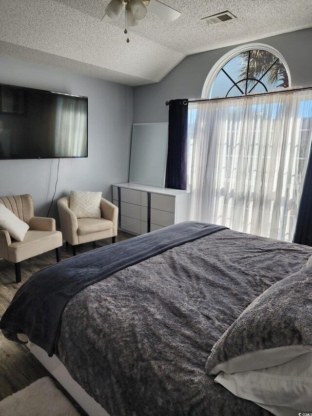 bedroom with ceiling fan, a textured ceiling, and vaulted ceiling