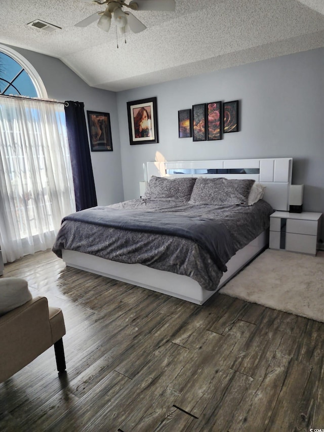 bedroom with a textured ceiling, ceiling fan, hardwood / wood-style floors, and lofted ceiling