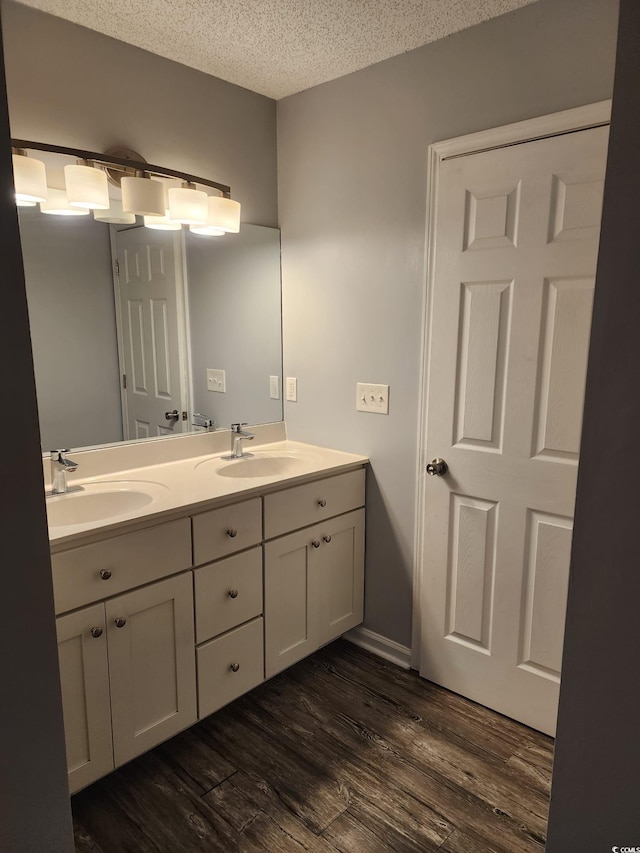 bathroom with hardwood / wood-style floors, vanity, and a textured ceiling