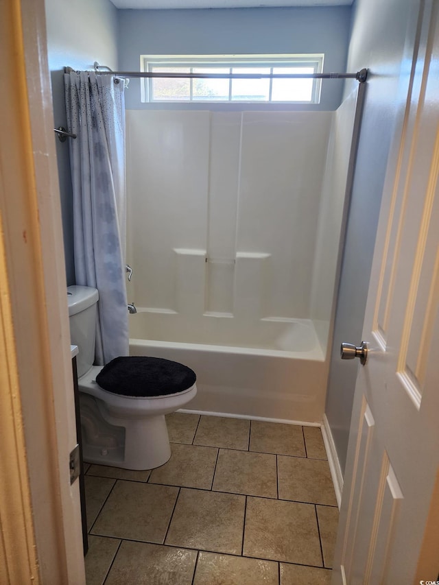 bathroom featuring tile patterned flooring, shower / bath combo, and toilet