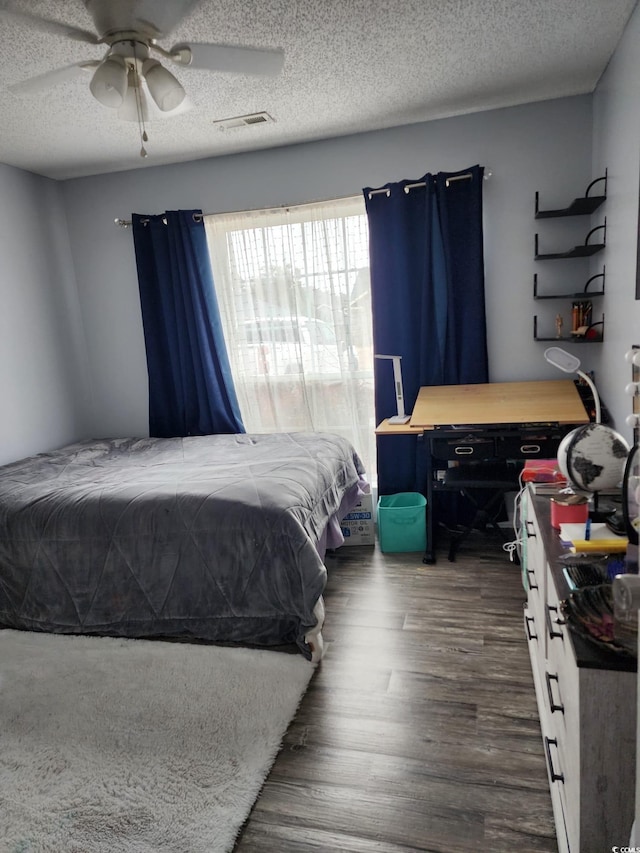 bedroom featuring a textured ceiling, dark hardwood / wood-style floors, and ceiling fan