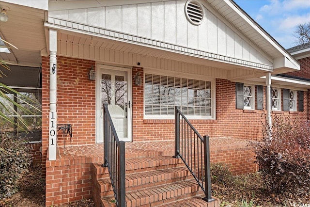 entrance to property with board and batten siding and brick siding