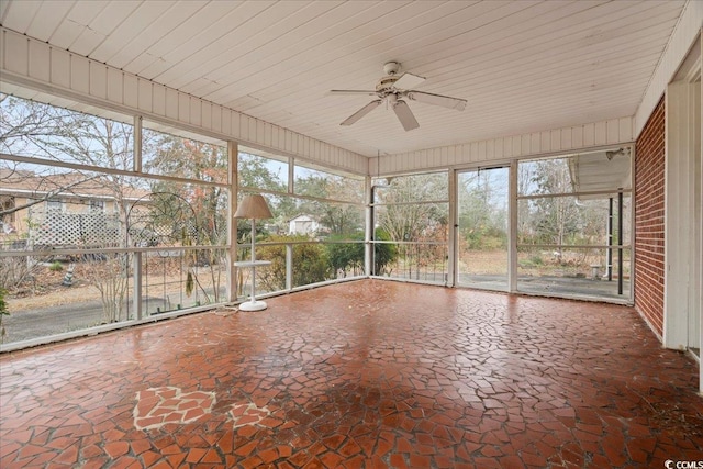 unfurnished sunroom with ceiling fan