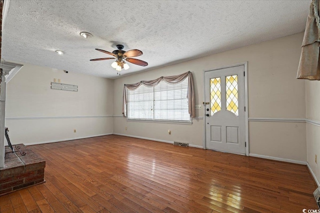 foyer entrance with a ceiling fan, baseboards, visible vents, and hardwood / wood-style floors