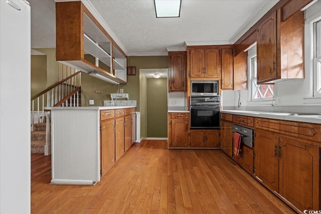 kitchen with brown cabinets, black oven, and stainless steel microwave