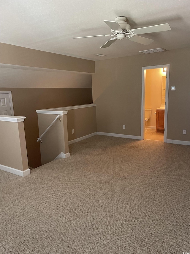 additional living space featuring ceiling fan and light colored carpet