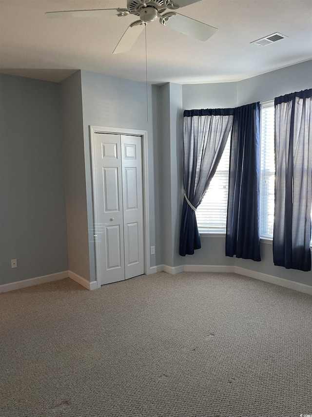 unfurnished bedroom featuring carpet flooring, ceiling fan, and a closet