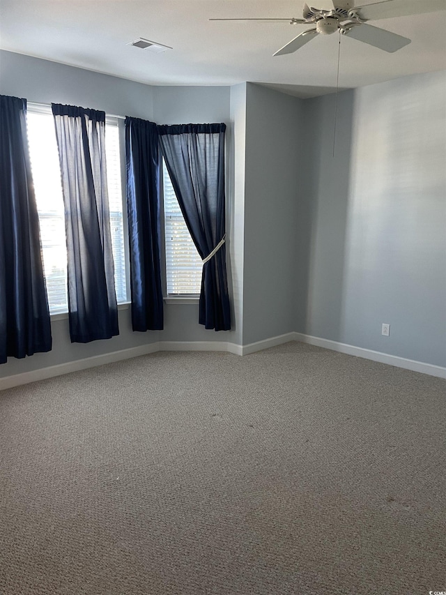 carpeted spare room featuring ceiling fan