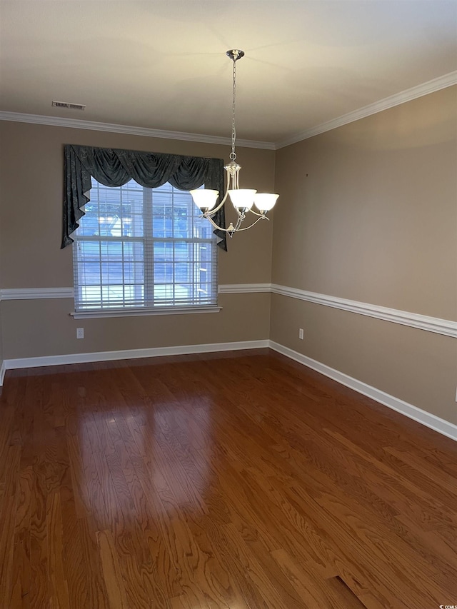 spare room featuring wood-type flooring, an inviting chandelier, and ornamental molding