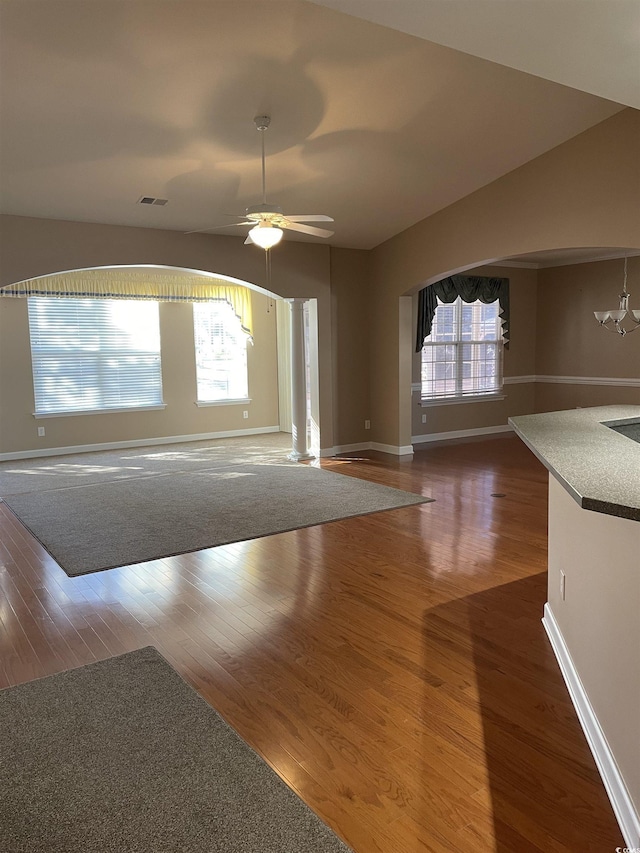 unfurnished living room with dark hardwood / wood-style floors and ceiling fan with notable chandelier