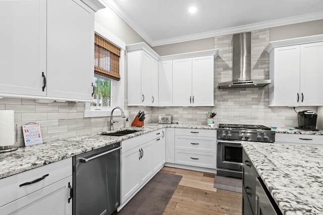 kitchen with white cabinetry, wall chimney range hood, and appliances with stainless steel finishes