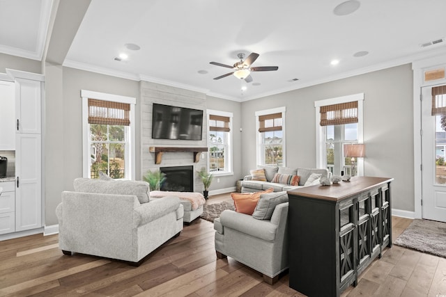 living room featuring a fireplace, crown molding, ceiling fan, and dark wood-type flooring