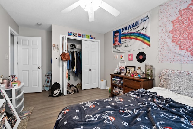 bedroom featuring a closet, a textured ceiling, a ceiling fan, and wood finished floors