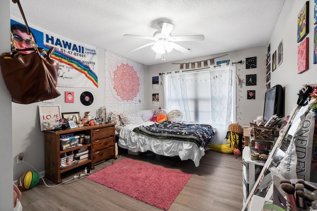 bedroom featuring ceiling fan, a textured ceiling, and wood finished floors