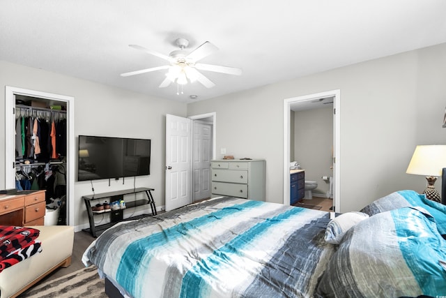 bedroom featuring a closet, a spacious closet, ensuite bath, and ceiling fan