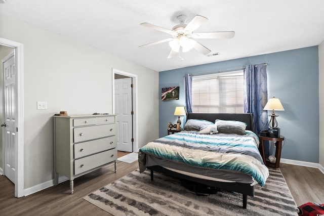 bedroom featuring visible vents, baseboards, and wood finished floors