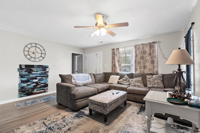 living area with wood finished floors, baseboards, and ceiling fan