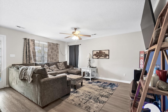 living room featuring hardwood / wood-style floors, a textured ceiling, and ceiling fan