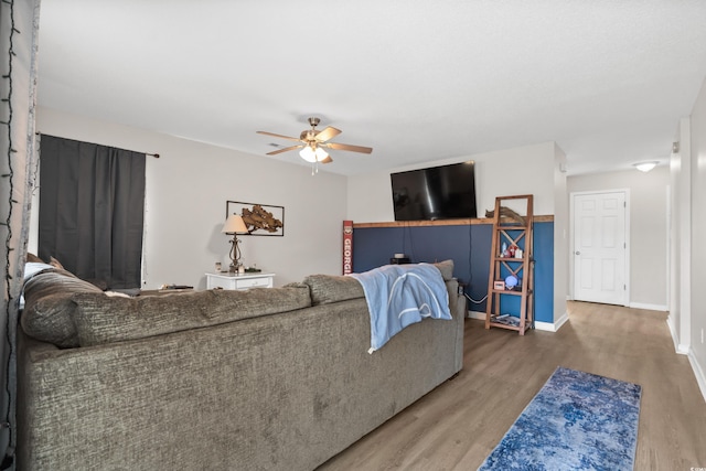 living room featuring wood-type flooring and ceiling fan