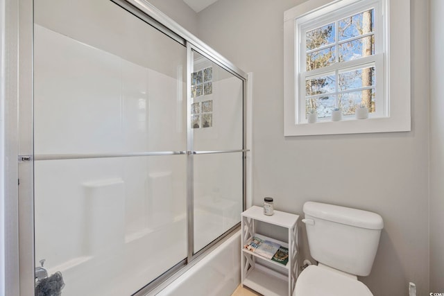 bathroom featuring toilet and enclosed tub / shower combo