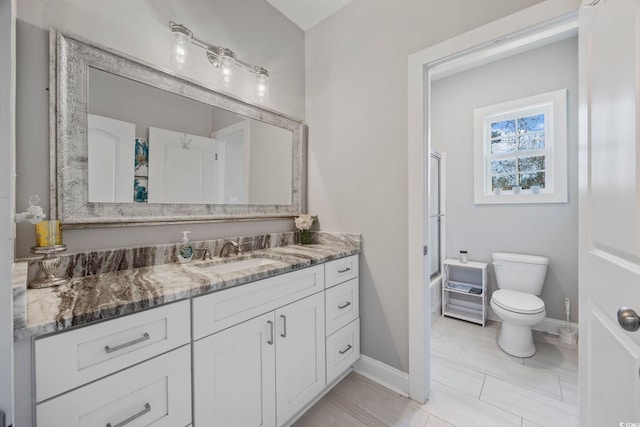 full bathroom featuring combined bath / shower with glass door, tile patterned floors, vanity, and toilet