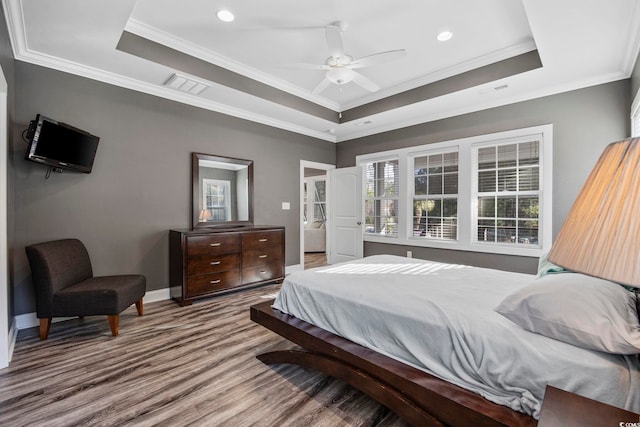 bedroom featuring ceiling fan, a raised ceiling, and ornamental molding