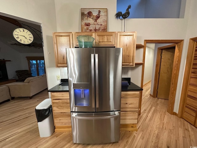 kitchen featuring stainless steel fridge with ice dispenser, light wood-type flooring, tasteful backsplash, and light brown cabinetry