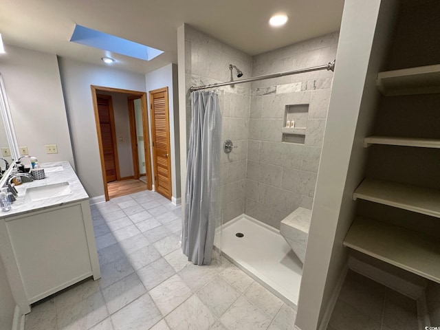 bathroom with a shower with shower curtain, vanity, and a skylight