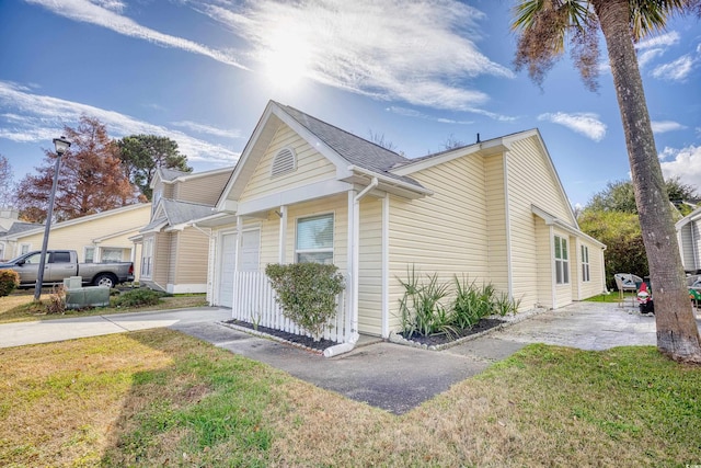 view of property exterior with a garage and a lawn