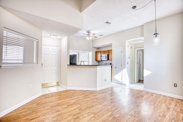 interior space featuring fridge, ceiling fan, plenty of natural light, and light wood-type flooring