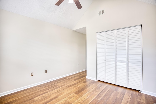 unfurnished bedroom with ceiling fan, wood-type flooring, a closet, and a textured ceiling