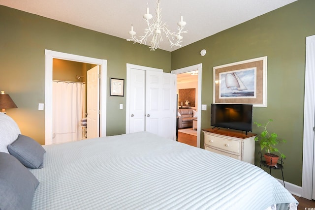 bedroom featuring ensuite bathroom, a closet, and a notable chandelier