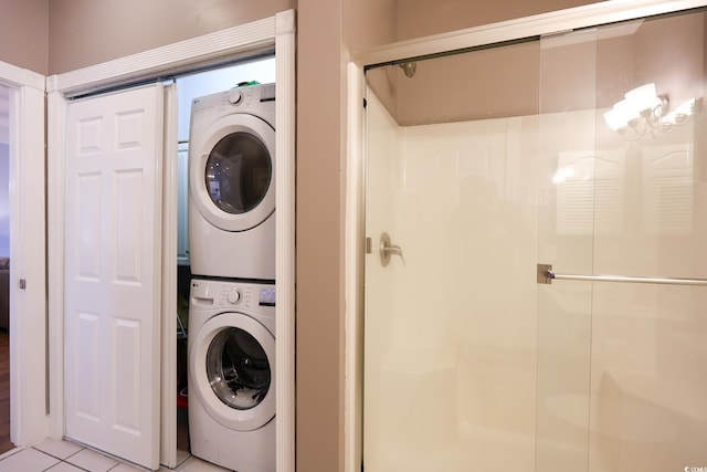 washroom with stacked washing maching and dryer and light tile patterned floors