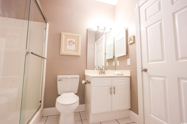 bathroom with vanity, tile patterned floors, a shower with door, and toilet