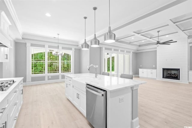 kitchen with appliances with stainless steel finishes, coffered ceiling, decorative light fixtures, white cabinetry, and an island with sink