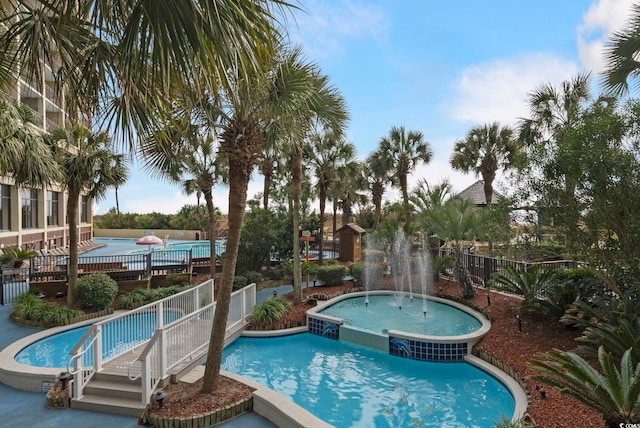 view of swimming pool featuring a hot tub and pool water feature