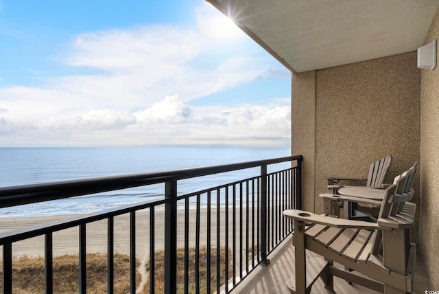 balcony featuring a water view and a beach view