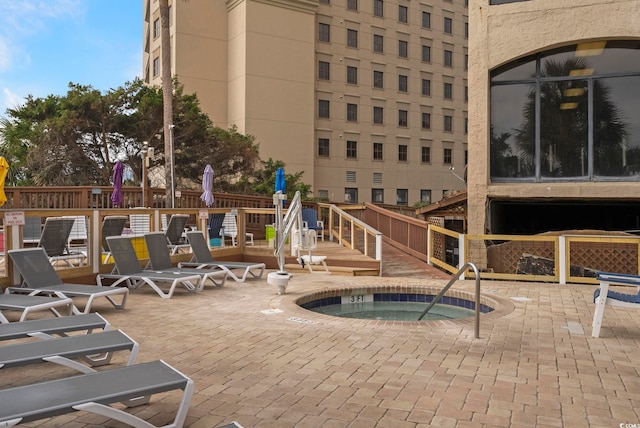 view of swimming pool featuring a hot tub, a playground, and a patio area