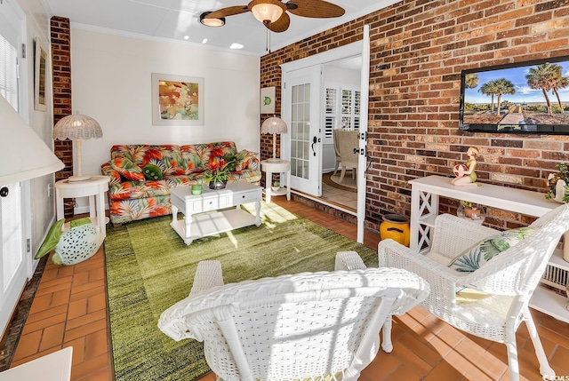 living room with ceiling fan, ornamental molding, and brick wall