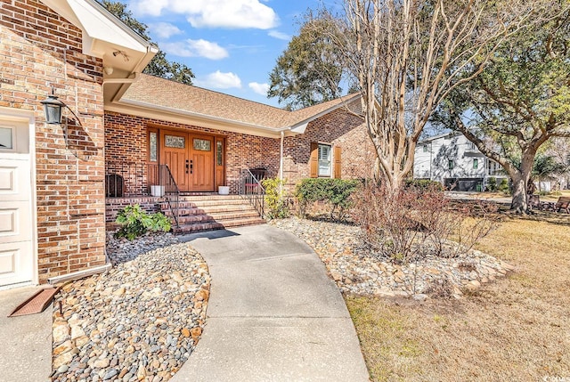 entrance to property with brick siding and roof with shingles