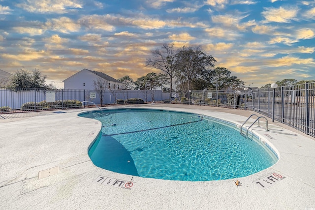 pool at dusk featuring a patio