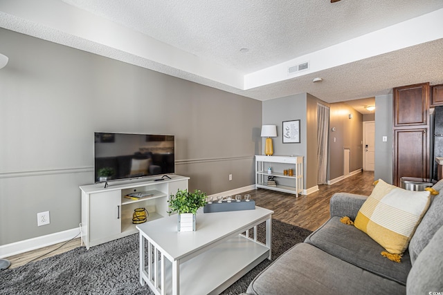 living room with dark hardwood / wood-style floors and a textured ceiling